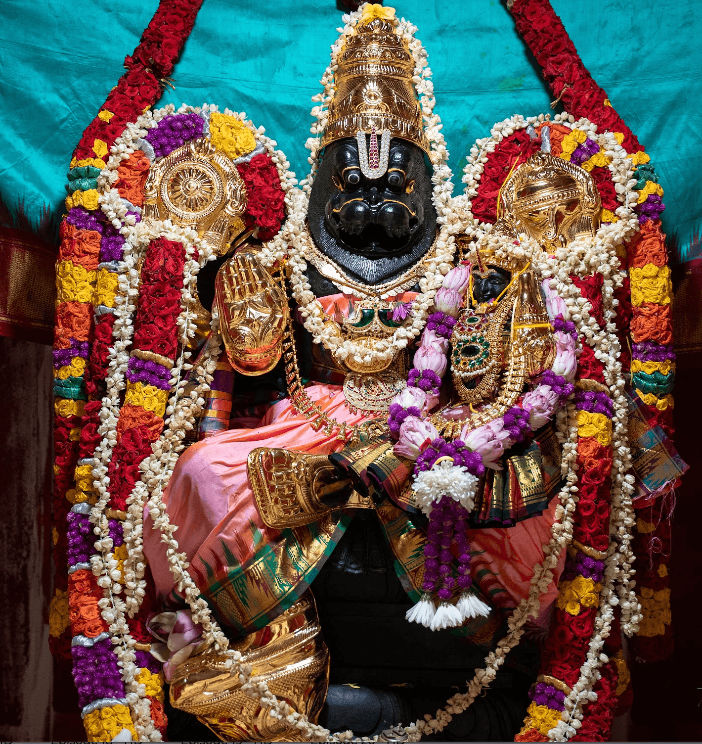 Lord Sri Lakshmi Narasimha with Goddess Lakshmi in the main shrine, adorned with gold kavacham, sudarshana chakra, conch, and flower garlands